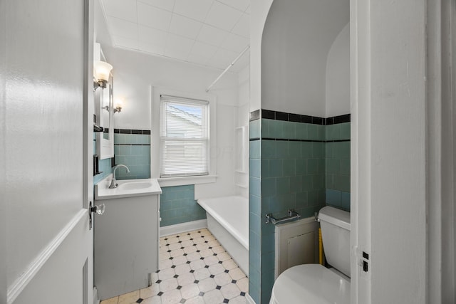 685 S Hague Ave, Columbus, OH 43204 - bathroom with tile walls, vanity, a wainscoted wall, tub / shower combination, and tile patterned floors