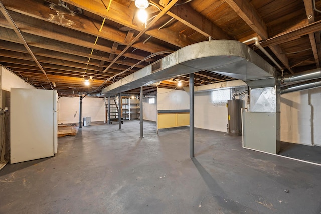 685 S Hague Ave, Columbus, OH 43204 - basement with water heater, heating unit, freestanding refrigerator, and stairway