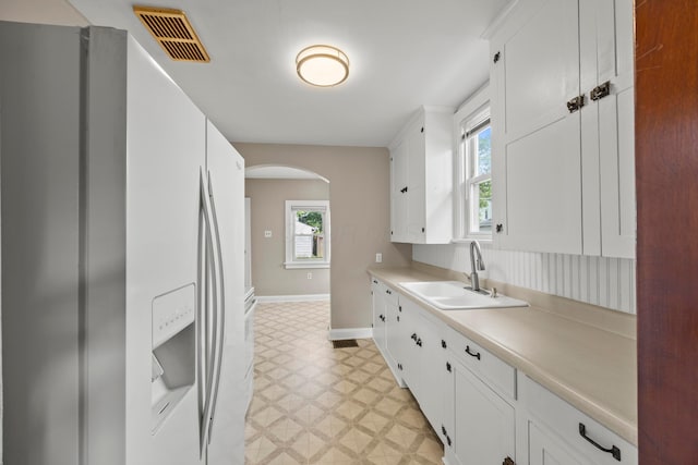 685 S Hague Ave, Columbus, OH 43204 - kitchen with white refrigerator with ice dispenser, light flooring, arched walkways, and plenty of natural light