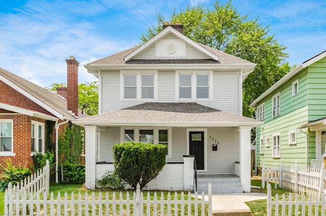 1233 Oakwood Ave, Columbus, OH 43206 - american foursquare style home with covered porch, roof with shingles, a chimney, and a fenced front yard