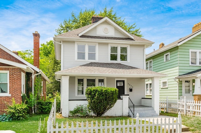 1233 Oakwood Ave, Columbus, OH 43206 - american foursquare style home featuring a fenced front yard, roof with shingles, and a porch