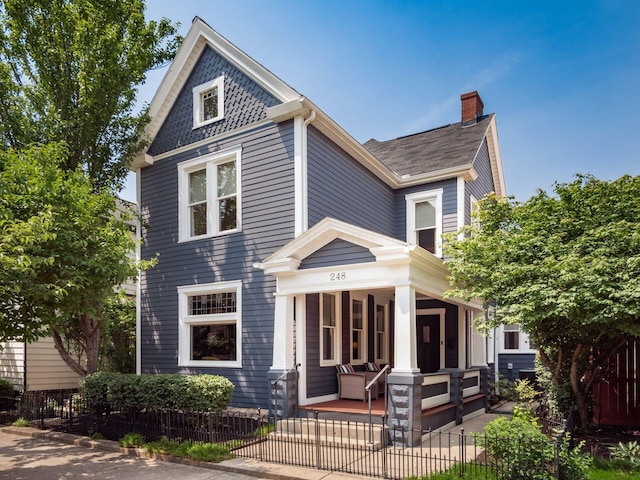 248 E Whittier St, Columbus, OH 43206 - victorian-style house featuring a porch, a chimney, and a fenced front yard