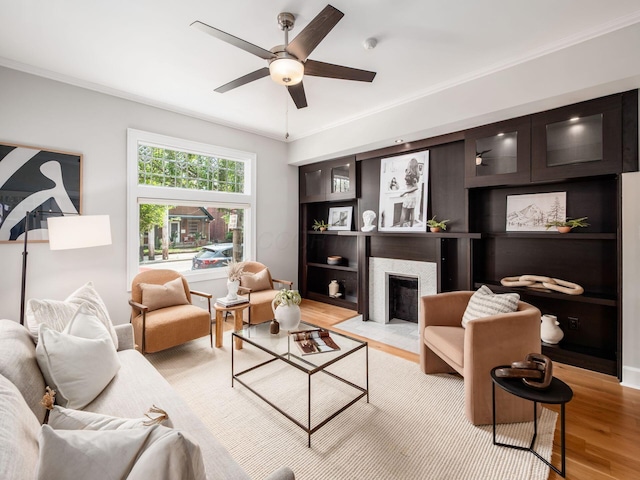 248 E Whittier St, Columbus, OH 43206 - living area with light wood-style floors, a fireplace with flush hearth, ornamental molding, and a ceiling fan