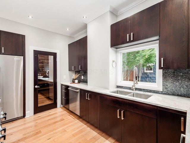 248 E Whittier St, Columbus, OH 43206 - kitchen featuring stainless steel appliances, crown molding, light wood finished floors, backsplash, and dark brown cabinetry