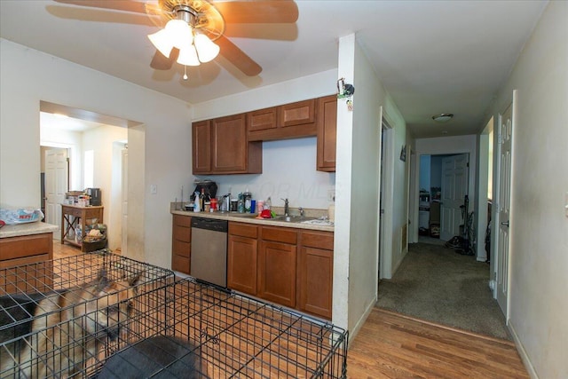 1935 Sedan Ave, Obetz, OH 43207 - kitchen with stainless steel dishwasher, brown cabinetry, light countertops, and wood finished floors