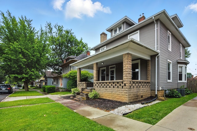 835 Rogers St, Bucyrus, OH 44820 - american foursquare style home featuring a chimney, a porch, and a front yard