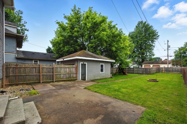 835 Rogers St, Bucyrus, OH 44820 - fenced backyard featuring a patio, an outbuilding, a playground, and an outdoor fire pit