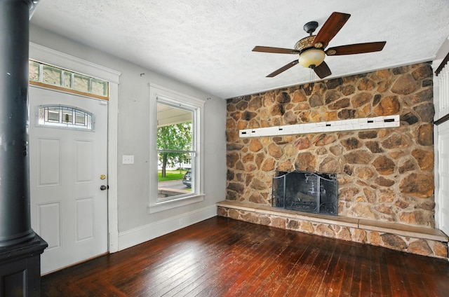 835 Rogers St, Bucyrus, OH 44820 - unfurnished living room featuring a wood stove, a textured ceiling, hardwood / wood-style floors, and ceiling fan