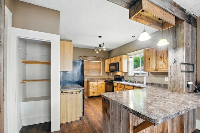 835 Rogers St, Bucyrus, OH 44820 - kitchen featuring black appliances, dark wood-style flooring, a peninsula, and pendant lighting