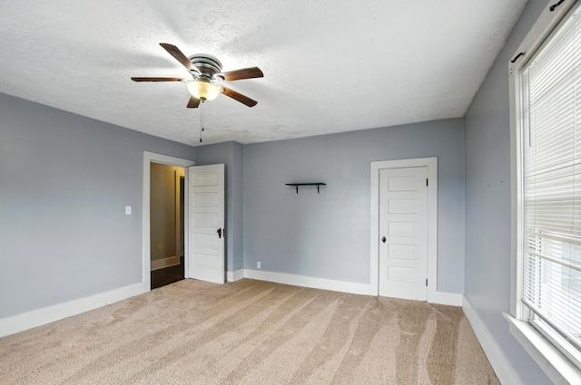 835 Rogers St, Bucyrus, OH 44820 - unfurnished bedroom with multiple windows, carpet, a textured ceiling, and a ceiling fan