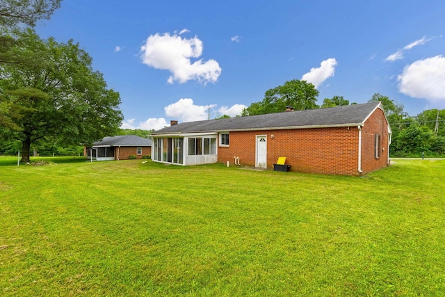 1508 W Hanley Rd, Mansfield, OH 44904 - back of property with a sunroom, brick siding, a lawn, and a chimney