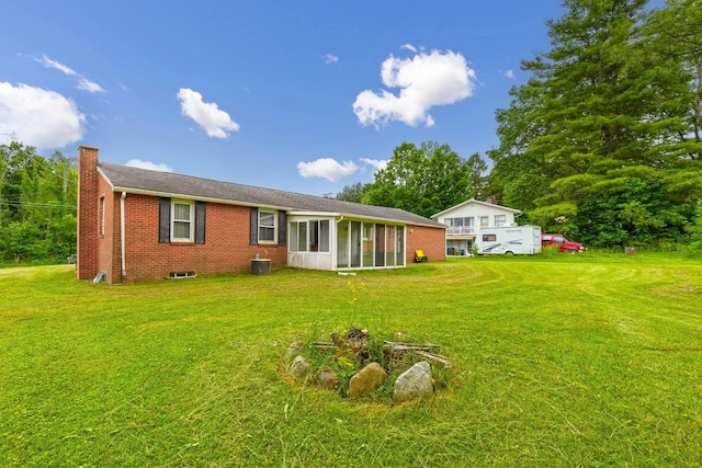 1508 W Hanley Rd, Mansfield, OH 44904 - back of property with brick siding, a chimney, a lawn, and a sunroom