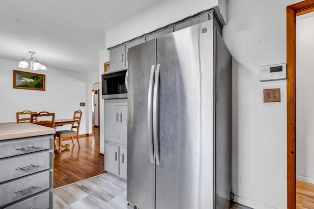 1508 W Hanley Rd, Mansfield, OH 44904 - kitchen with stainless steel appliances, gray cabinets, a chandelier, light wood finished floors, and light countertops