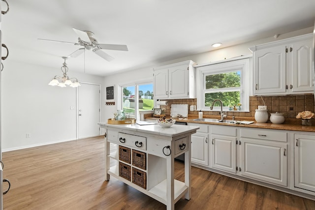 65 Jeffery Ln SE, Heath, OH 43056 - kitchen featuring decorative backsplash, white cabinets, a ceiling fan, wood finished floors, and recessed lighting