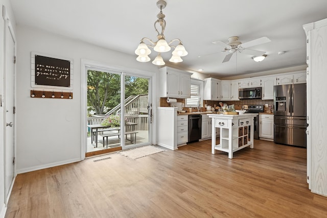 65 Jeffery Ln SE, Heath, OH 43056 - kitchen with appliances with stainless steel finishes, decorative backsplash, ceiling fan, light wood finished floors, and a kitchen island