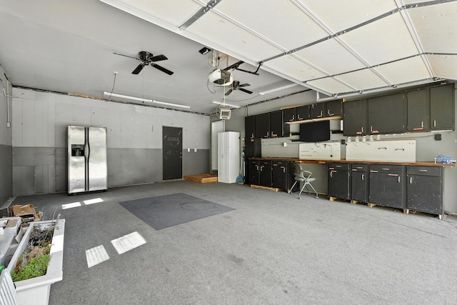 65 Jeffery Ln SE, Heath, OH 43056 - garage with stainless steel fridge with ice dispenser, a garage door opener, a workshop area, and a ceiling fan