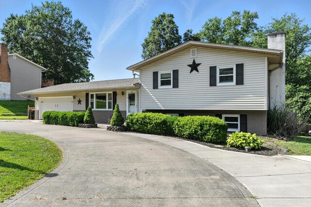 65 Jeffery Ln SE, Heath, OH 43056 - split level home featuring a chimney, an attached garage, and driveway