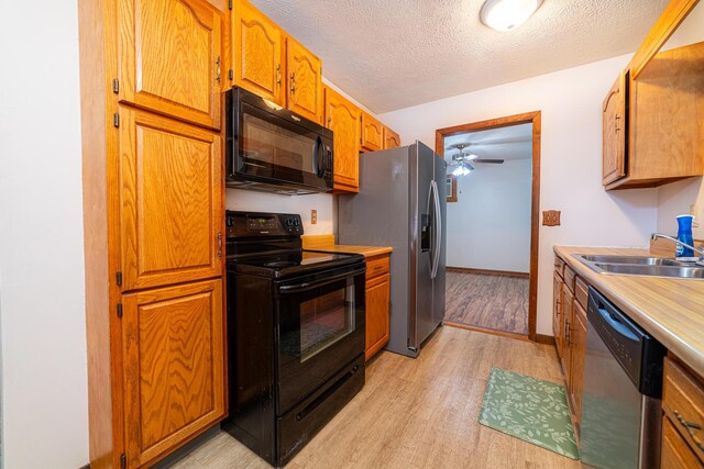 1892 County Road 170, Marengo, OH 43334 - kitchen with black appliances, light wood finished floors, a textured ceiling, light countertops, and a ceiling fan