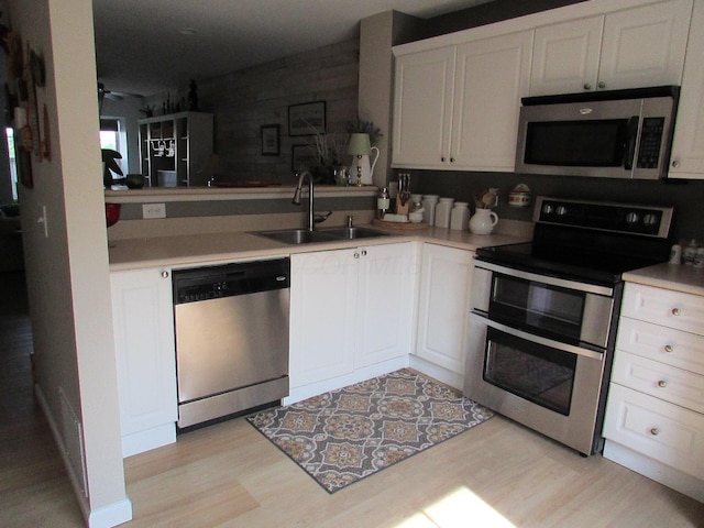 6038 Phar Lap Dr, New Albany, OH 43054 - kitchen featuring appliances with stainless steel finishes, light wood-style floors, light countertops, and white cabinetry