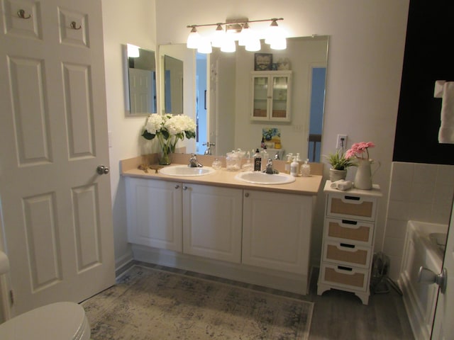 6038 Phar Lap Dr, New Albany, OH 43054 - full bath with double vanity, a bathtub, and wood finished floors