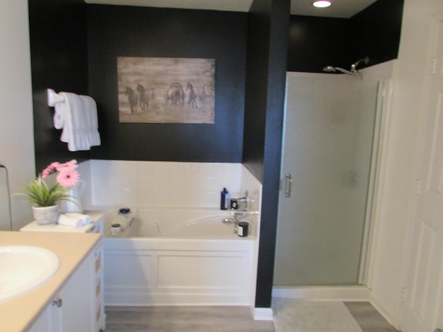6038 Phar Lap Dr, New Albany, OH 43054 - full bathroom featuring a stall shower, a garden tub, wood finished floors, and vanity