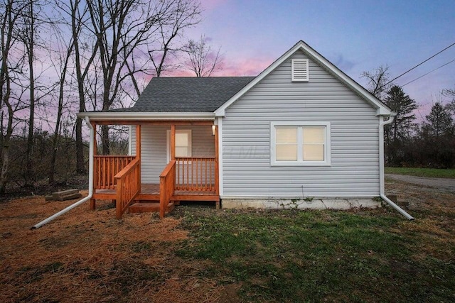 3784 Armuth Ave, Columbus, OH 43219 - back of house at dusk featuring a porch and roof with shingles