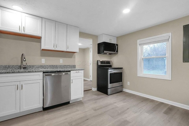 3784 Armuth Ave, Columbus, OH 43219 - kitchen with stainless steel appliances, light wood-type flooring, light stone counters, and white cabinetry