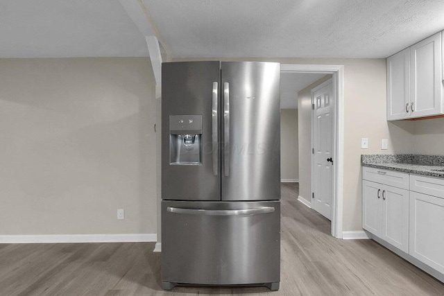 3784 Armuth Ave, Columbus, OH 43219 - kitchen with stainless steel fridge with ice dispenser, light wood finished floors, white cabinets, light stone counters, and a textured ceiling