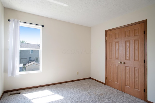 237 Harvard Loop, Delaware, OH 43015 - unfurnished bedroom featuring carpet floors, a closet, and a textured ceiling