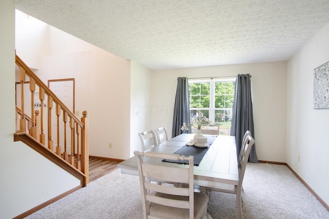 237 Harvard Loop, Delaware, OH 43015 - dining space featuring light carpet, stairway, and a textured ceiling