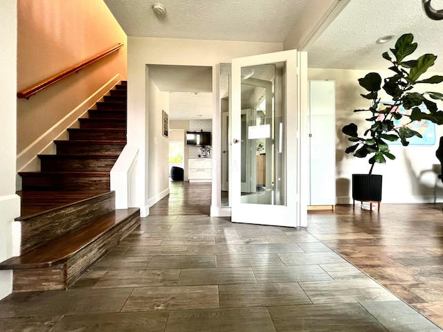 8576 Army Pl, Galloway, OH 43119 - foyer featuring stairs, a textured ceiling, and dark wood-style flooring