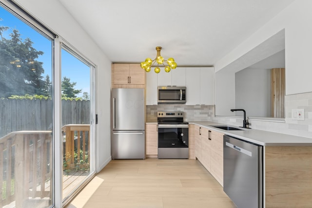 914 Worthington Woods Blvd Unit 11, Columbus, OH 43085 - kitchen with appliances with stainless steel finishes, a chandelier, decorative backsplash, light countertops, and light brown cabinets