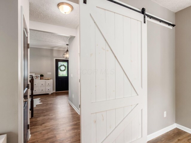 153 Shawnee Dr, Pickerington, OH 43147 - hallway featuring a textured ceiling, a barn door, and dark wood-style flooring