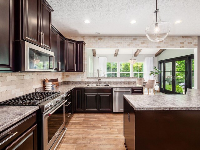153 Shawnee Dr, Pickerington, OH 43147 - kitchen with appliances with stainless steel finishes, light wood-style flooring, dark brown cabinets, light countertops, and pendant lighting