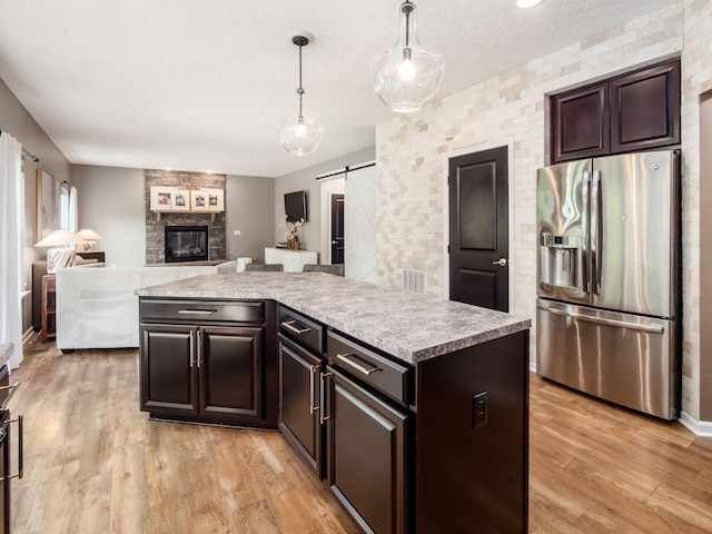 153 Shawnee Dr, Pickerington, OH 43147 - kitchen featuring stainless steel refrigerator with ice dispenser, a barn door, light countertops, a center island, and light wood-style floors