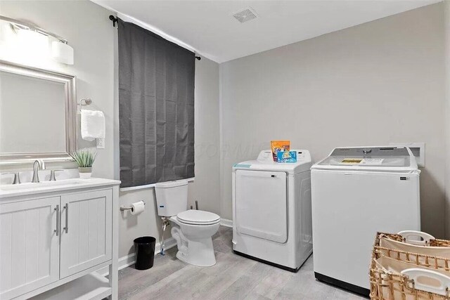 387 N Garfield Ave, Columbus, OH 43203 - laundry room with washer and clothes dryer and light wood-type flooring