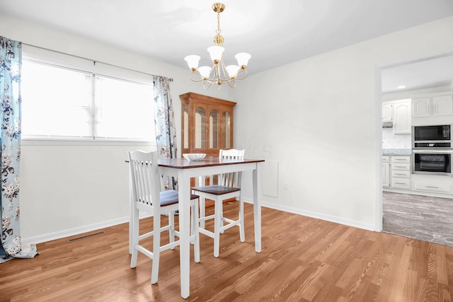 1121 Afton Rd, Columbus, OH 43221 - dining room with a chandelier and light wood-type flooring
