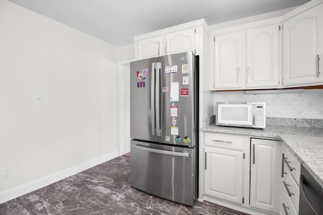 1121 Afton Rd, Columbus, OH 43221 - kitchen with freestanding refrigerator, white microwave, white cabinets, light stone counters, and dark marble finish floors