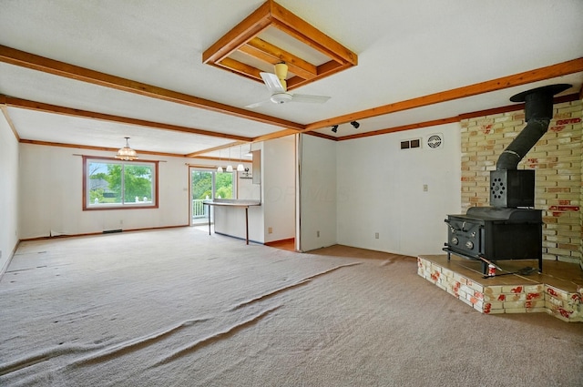4985 N Lake Hill Dr, Delaware, OH 43015 - unfurnished living room featuring a wood stove, carpet flooring, beamed ceiling, and ceiling fan