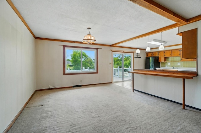 4985 N Lake Hill Dr, Delaware, OH 43015 - kitchen featuring freestanding refrigerator, light colored carpet, beam ceiling, brown cabinets, and a textured ceiling