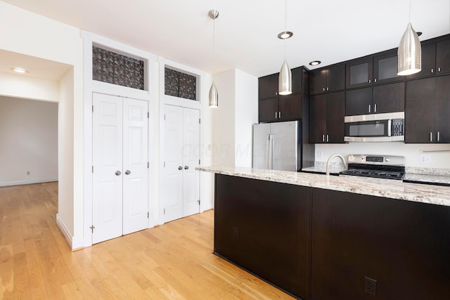 318 Berger Aly, Columbus, OH 43206 - kitchen featuring appliances with stainless steel finishes, light wood-type flooring, hanging light fixtures, light stone countertops, and recessed lighting