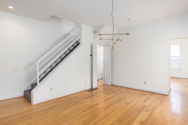318 Berger Aly, Columbus, OH 43206 - unfurnished living room with stairway, light wood-type flooring, a chandelier, and recessed lighting