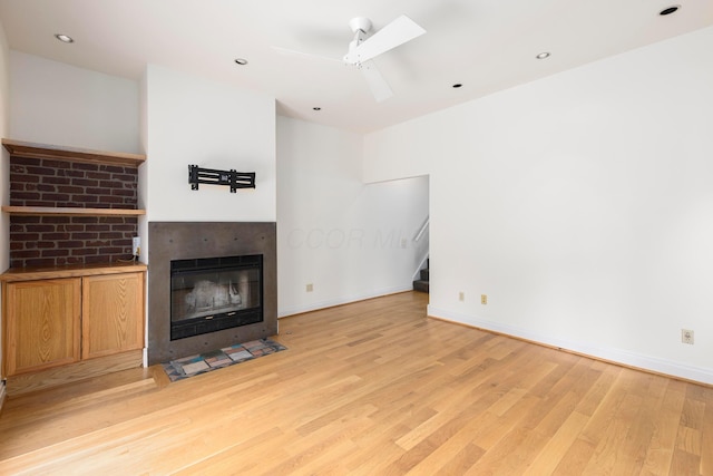 318 Berger Aly, Columbus, OH 43206 - unfurnished living room with light wood finished floors, stairs, a fireplace with flush hearth, and a ceiling fan