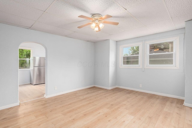 424 S Harris Ave, Columbus, OH 43204 - spare room featuring a drop ceiling, ceiling fan, light wood-type flooring, and arched walkways