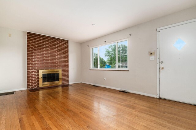 1208 Carolwood Ave, Columbus, OH 43227 - unfurnished living room featuring hardwood / wood-style floors and a fireplace