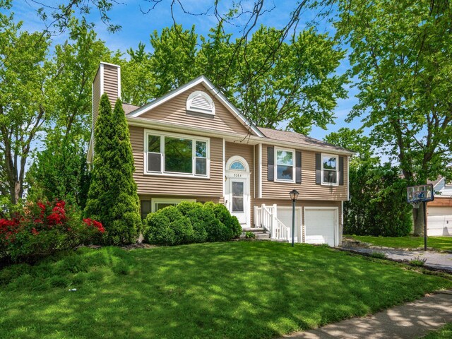 5264 Davidson Rd, Hilliard, OH 43026 - raised ranch featuring a chimney, an attached garage, a front yard, and driveway