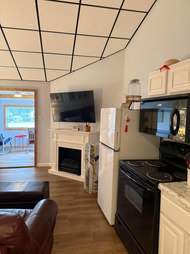 13997 Custers Point Rd NE, Thornville, OH 43076 - kitchen with black appliances, open floor plan, wood finished floors, a drop ceiling, and white cabinets