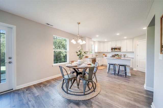 66 Genoa Cir, Commercial Point, OH 43116 - dining space featuring healthy amount of natural light, light wood-type flooring, a chandelier, recessed lighting, and a textured ceiling