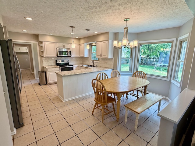 1724 Ramblewood Ave, Columbus, OH 43235 - kitchen with stainless steel appliances, light tile patterned flooring, decorative backsplash, plenty of natural light, and a textured ceiling