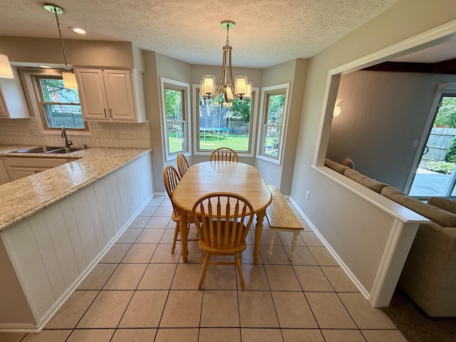 1724 Ramblewood Ave, Columbus, OH 43235 - dining room featuring light tile patterned flooring, a chandelier, and a textured ceiling